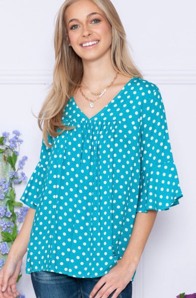 Model wearing our Jade Polka Dot Ruffle Sleeve Top. The top is 3/4 quarter sleeve with a wide bell effect. There is a v neckline and polka dot patterns.