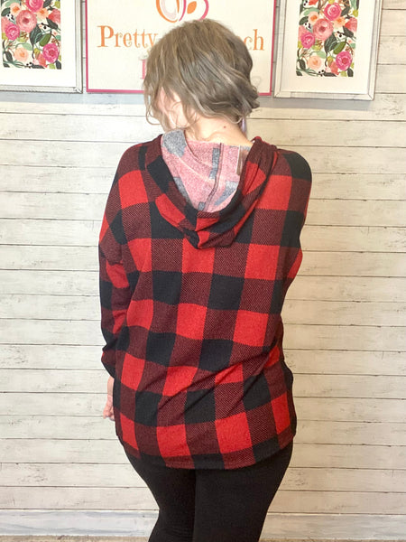 Model wearing our Black & Red Buffalo Plaid Hoodie. Hoodie has a small slit on either side at the bottom and black ties. The sweatshirt is legging friendly.  Edit alt text
