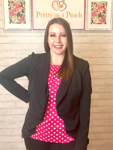 Model wearing our black open blazer. The blazer has a flattering cut that rounds out. Model pairs this blazer with our emerald and mustard maxi dress.