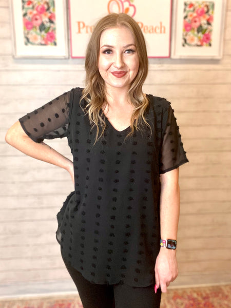 Model wearing our black swiss dot top! The top is short sleeve and neck. The sleeves are sheer but the rest of the top is not. 