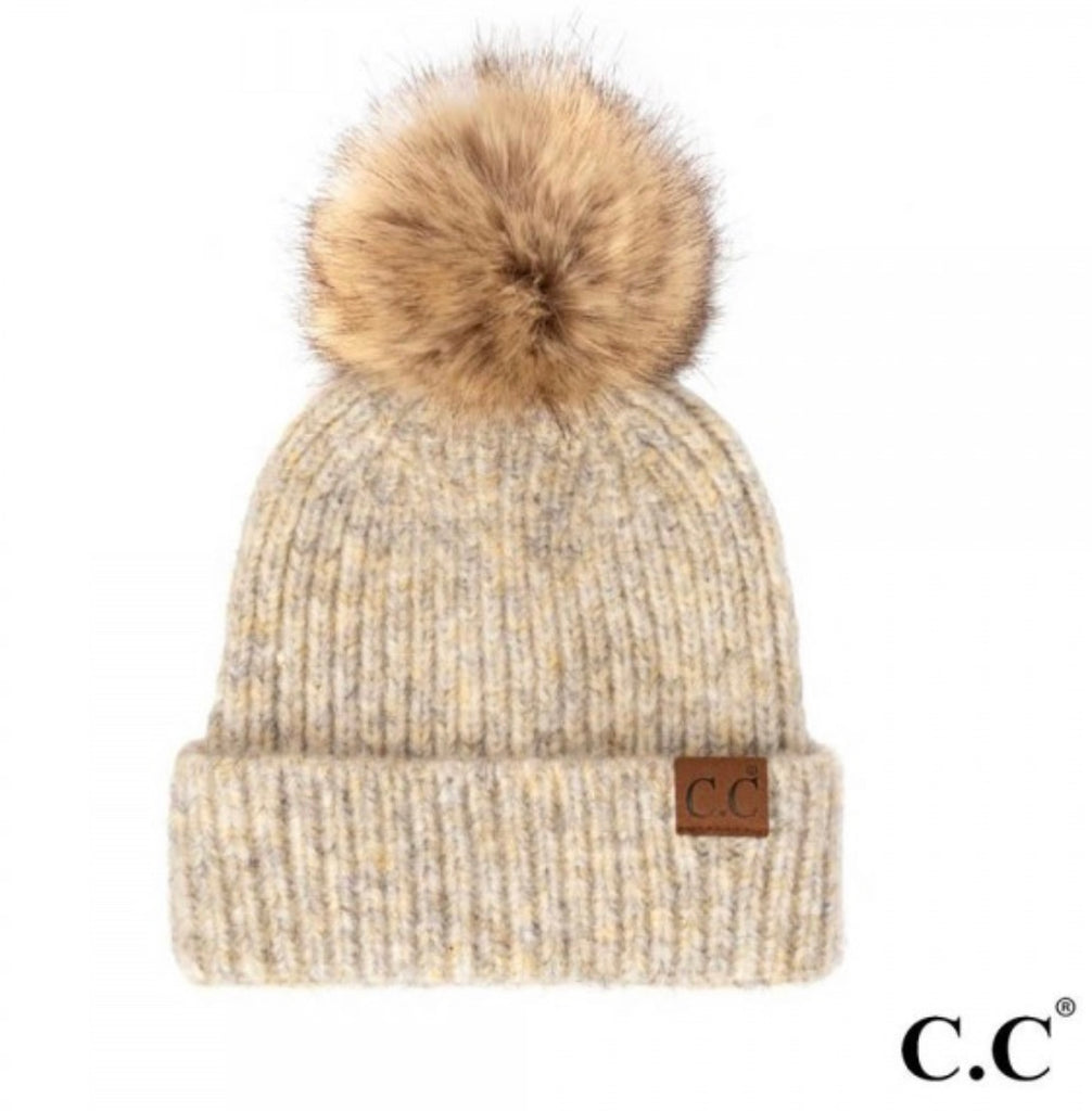 Flat lay photo of our CC Beanie Cream Heathered Pom Beanie. CC logo is in the right side. Pom pom is fur like and brown. Beanie is cream/beige heathered color.